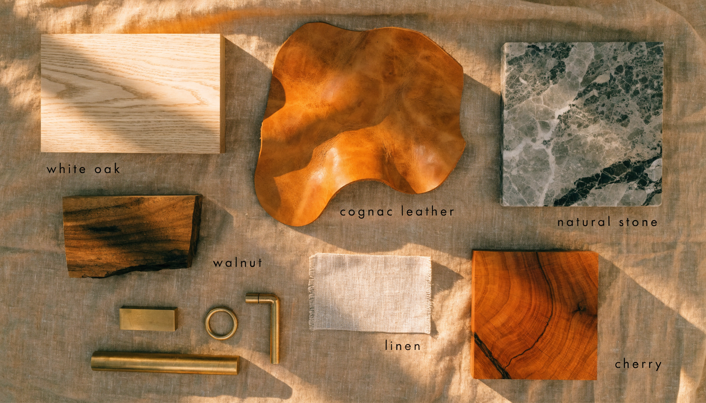 Natural material samples — oak, walnut, leather, brass