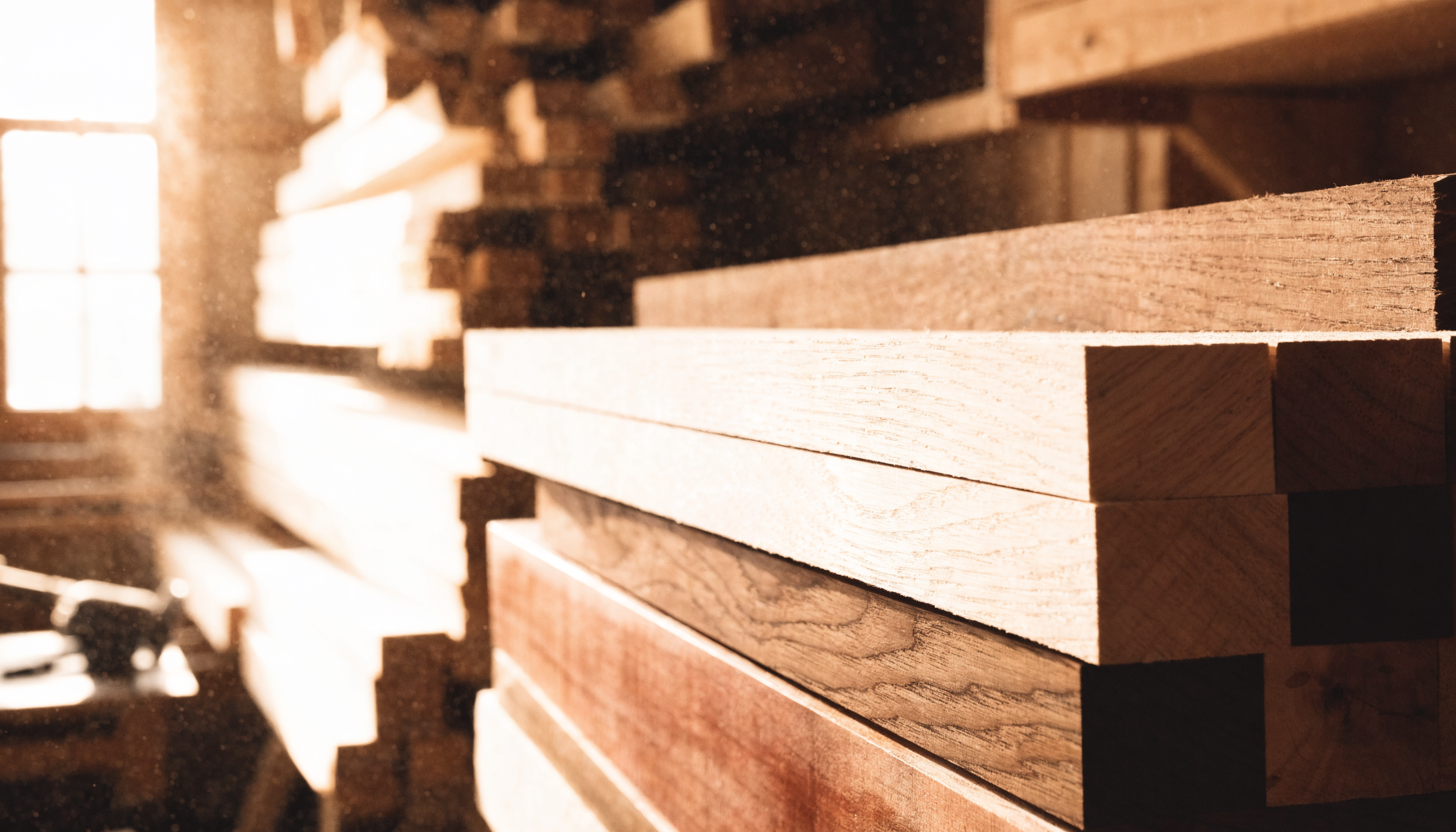 Raw wood planks in a sunlit workshop